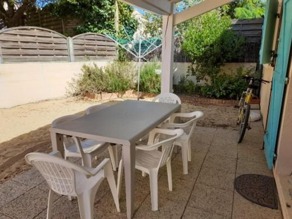 a white table and chairs under an umbrella at Maison Bretignolles-sur-Mer, 4 pièces, 7 personnes - FR-1-324-198 in Bretignolles-sur-Mer