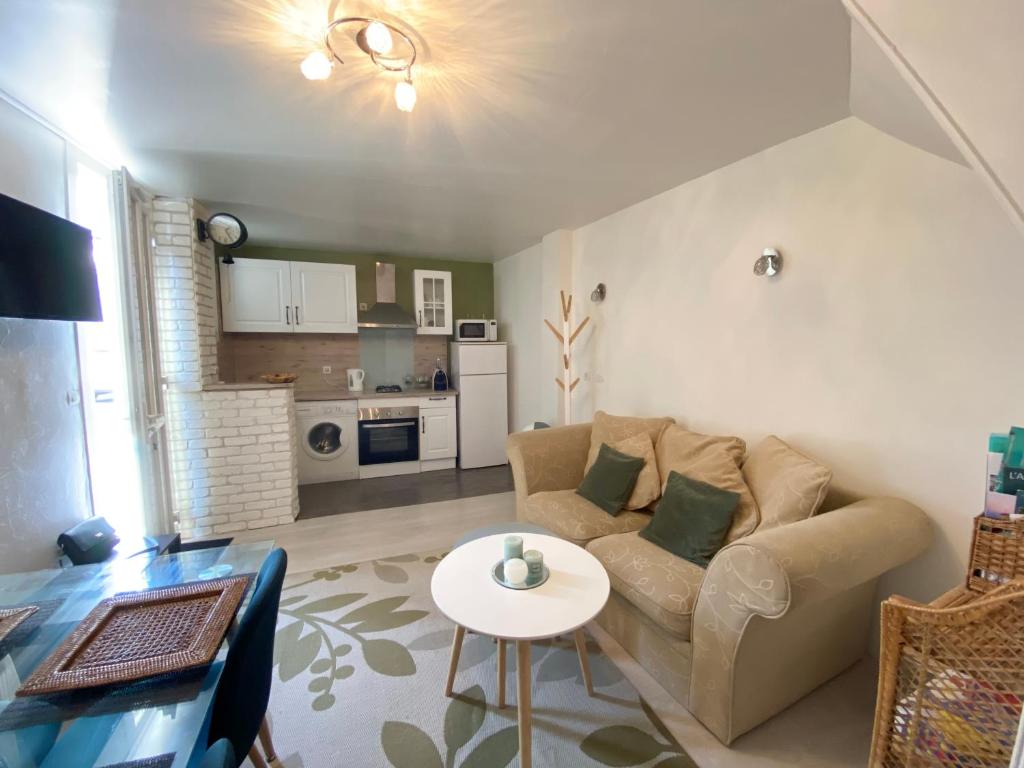 un salon avec un canapé et une table dans l'établissement L’ardoisière, à Honfleur