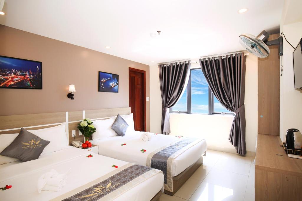 ダナンにあるThành Nhân Hotelのベッドが2つと窓があるホテルの部屋