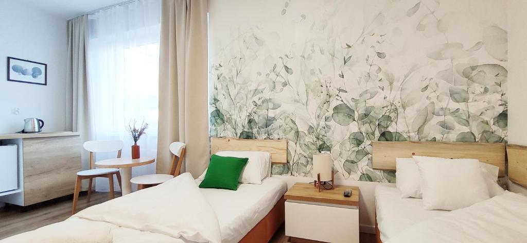a hotel room with two beds and a painting on the wall at Zielona Noc in Polanica-Zdrój