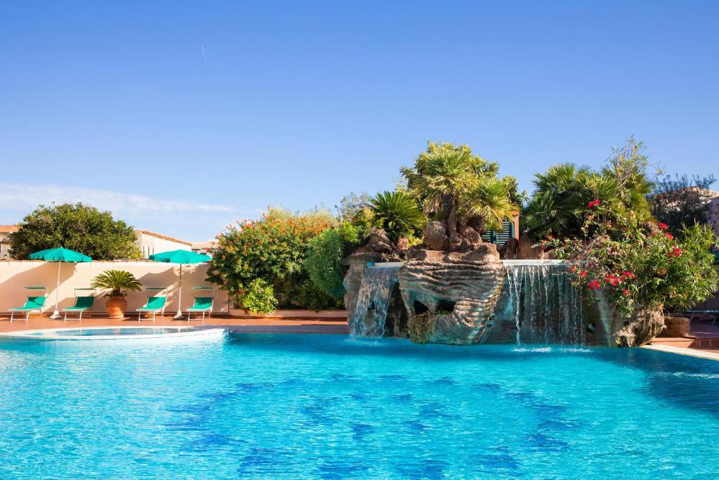 einen Pool mit Wasserfall in einem Resort in der Unterkunft Hotel Maria Rosaria in Orosei