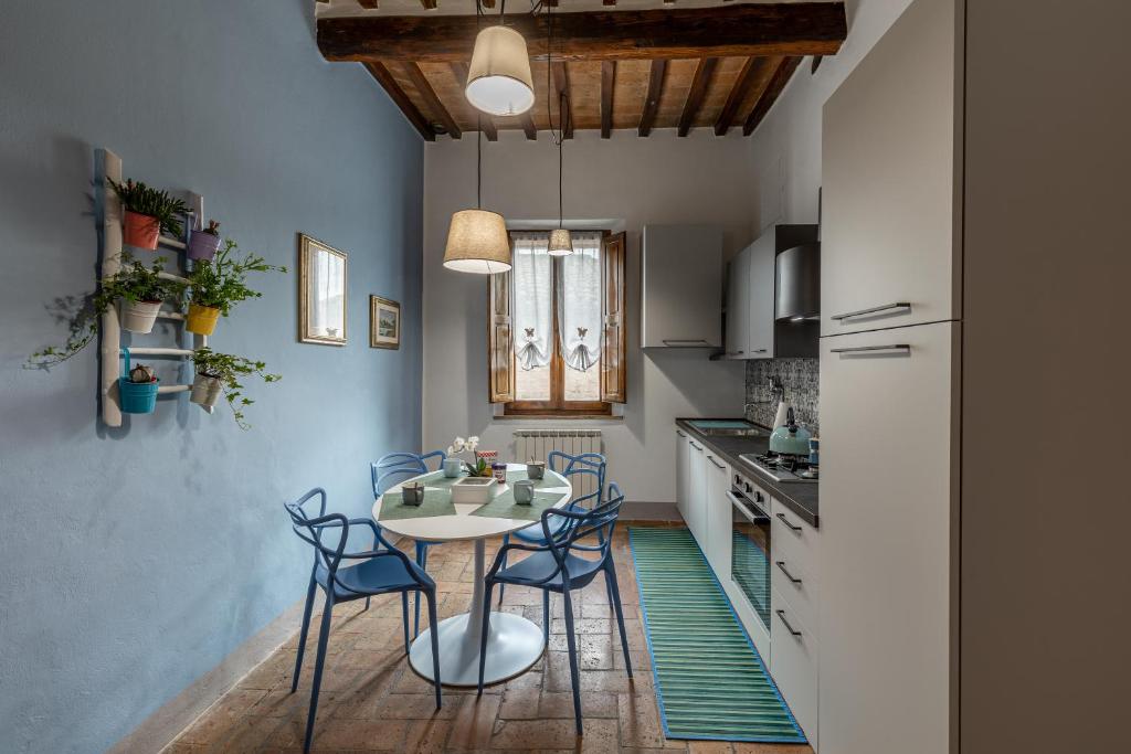 a kitchen with a table and chairs in a room at La sosta di Arrigo in Buonconvento