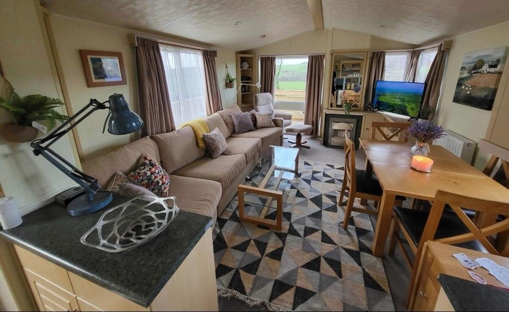 a living room with a couch and a table at FAB Caravan Holiday Home in Colmonell