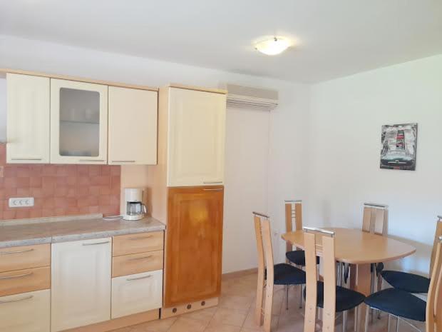 a kitchen with a table and a table and chairs at APARTMANI DELAS in Pješčana Uvala