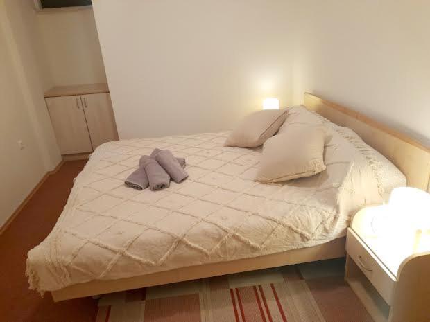 a bed with two pillows on it in a room at APARTMANI DELAS in Pješčana Uvala