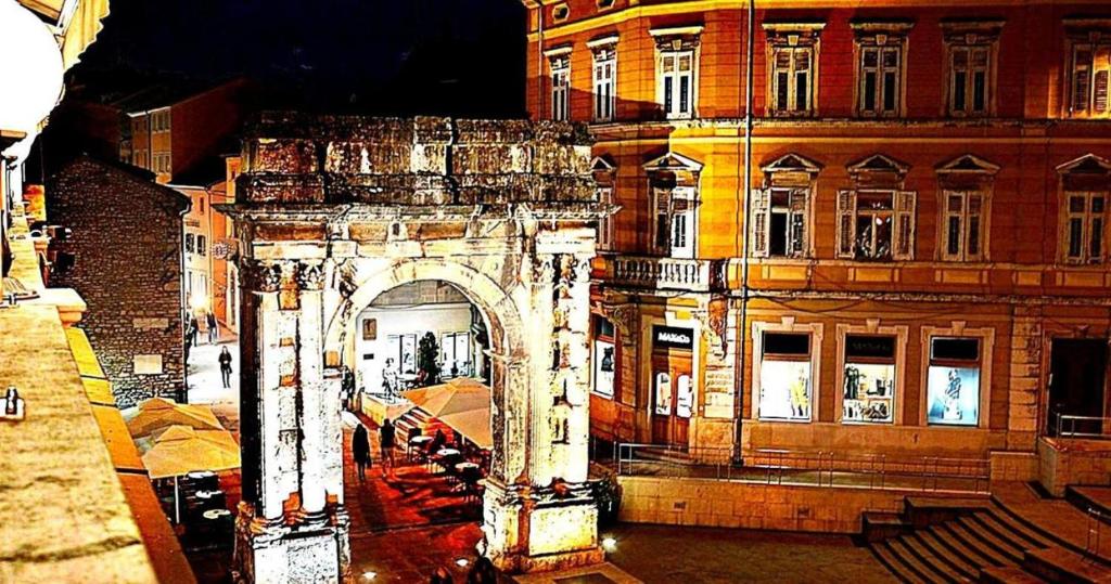 a building with an arch in a city at night at APARTMANI DELAS in Pješčana Uvala 