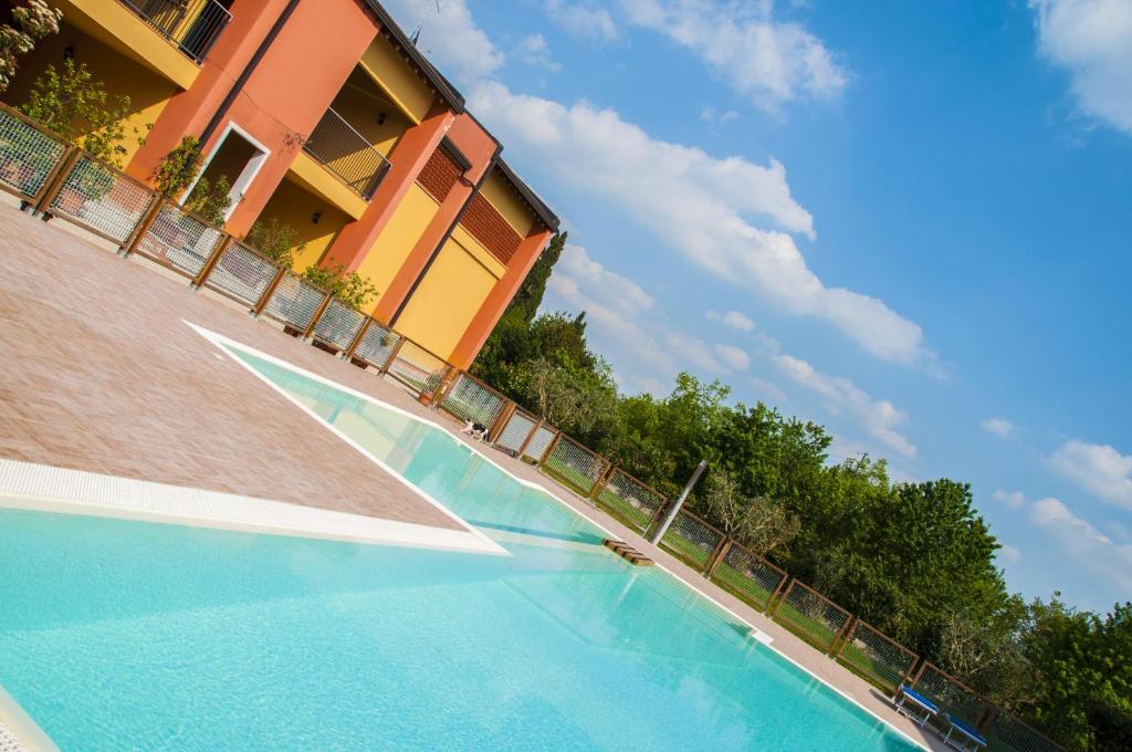 a swimming pool in front of a building at Agriturismo Ai Tre Fienili in Ponti Sul Mincio