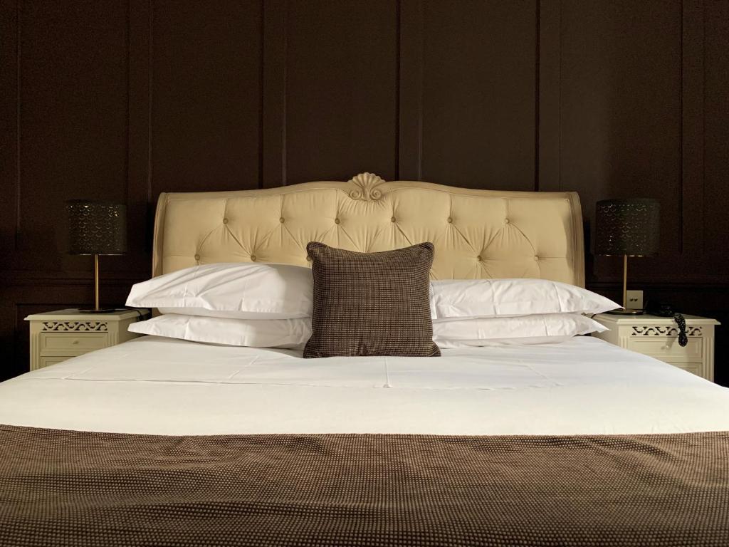 a large white bed with a pillow on it at The Bell Inn Hotel in Horndon on the Hill