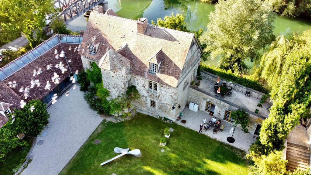 an aerial view of a large house with a clock on the lawn at Le Prieuré sur Seine in Marnay-sur-Seine