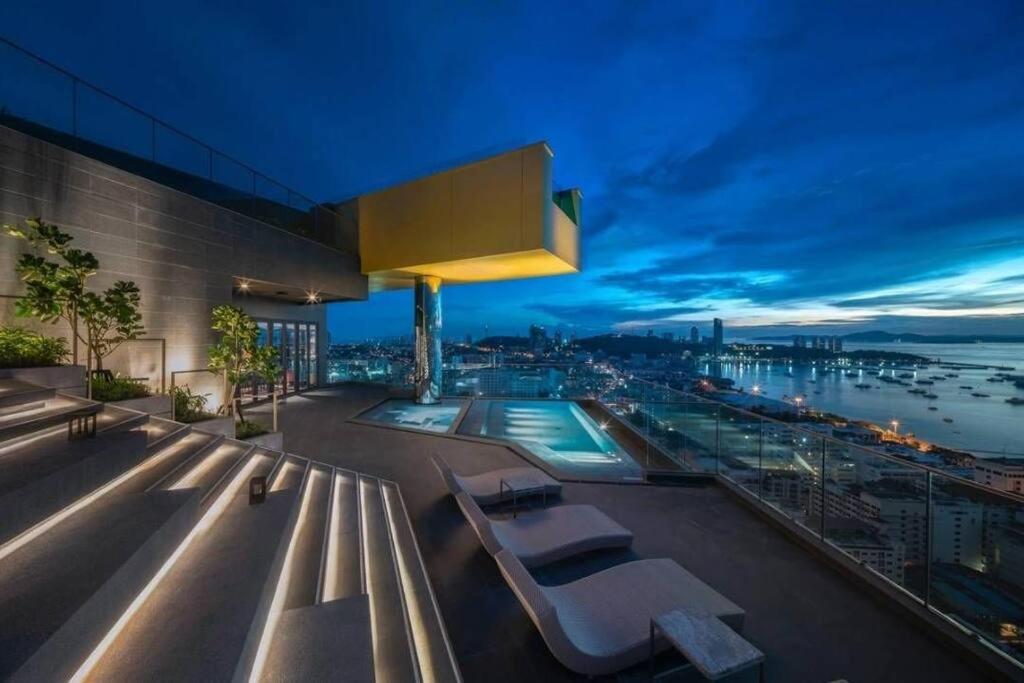 a building with a view of a harbor at night at Edge Luxury Ocean view Pattaya in Pattaya