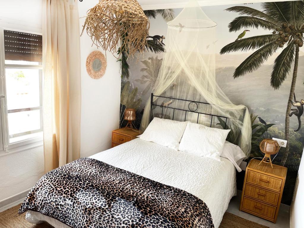 1 dormitorio con 1 cama en blanco y negro y un mural de palmeras en Apartamento temático con Sala de Juegos - Prime Video!, en Ariza
