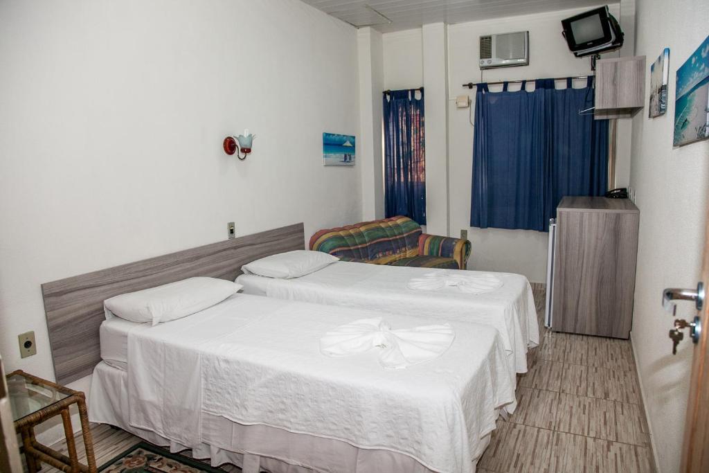 1 dormitorio con 2 camas con sábanas blancas en Residencial Ilha Dourada en Florianópolis
