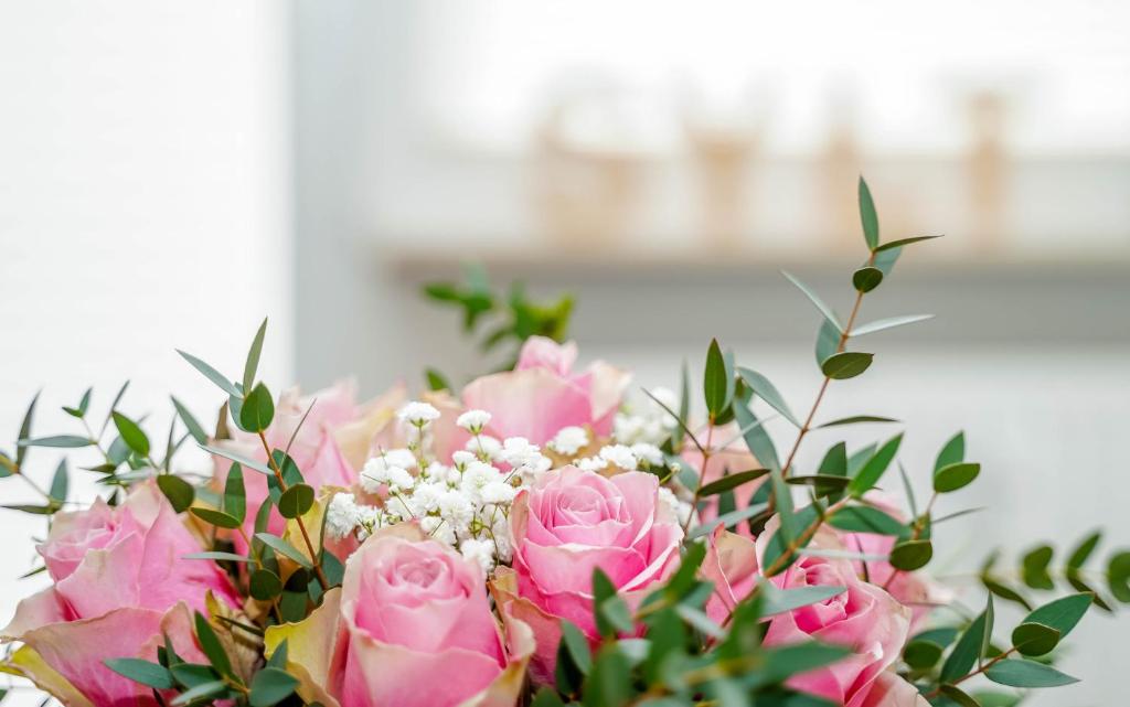 ein Strauß rosa Rosen in einer Vase in der Unterkunft Ferienwohnung Di Südlöner in Westerland