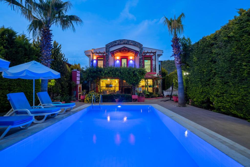 a swimming pool in front of a house at Terra Kaya Villa in Kayakoy