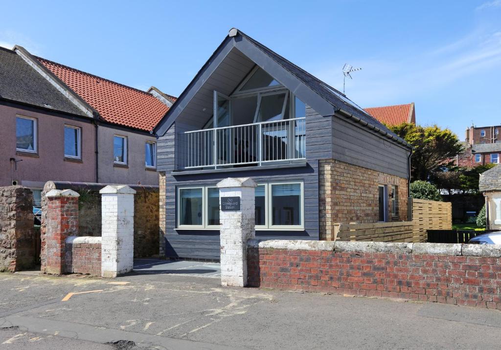 uma casa com uma parede de tijolos em Old Coastguard Station em Dunbar