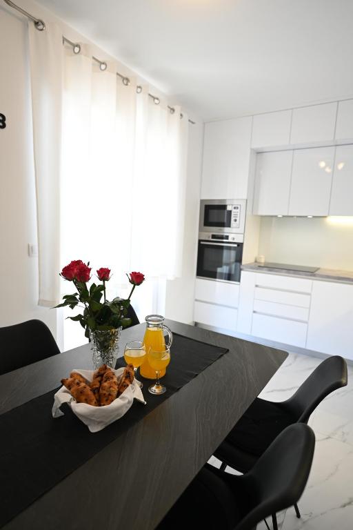 een keuken met een tafel met een bord eten en sinaasappelsap bij NEW comfortable Apartment Vesna in Hvar