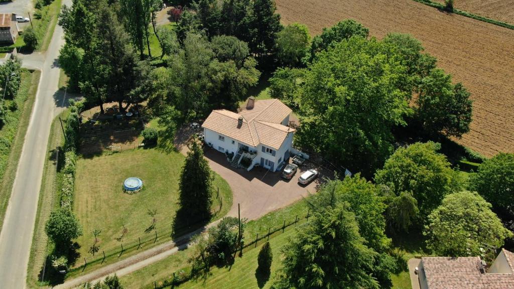 a large white house with a driveway and trees at La Folie in Breuil-Barret