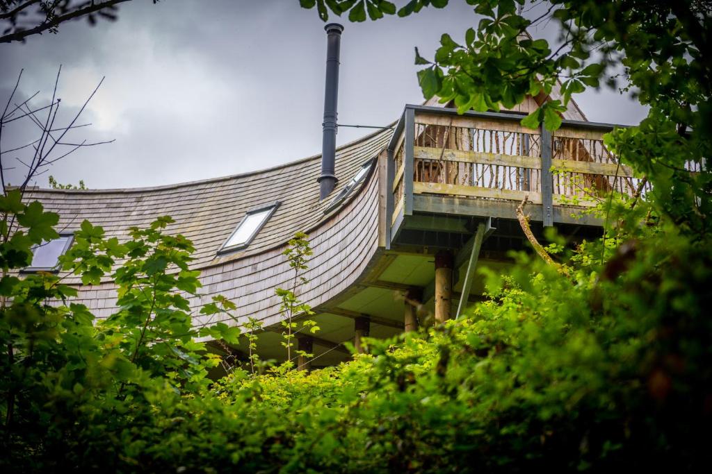 a building with a staircase on the side of it at Skapya Treehouse with private hot tub . in Helston