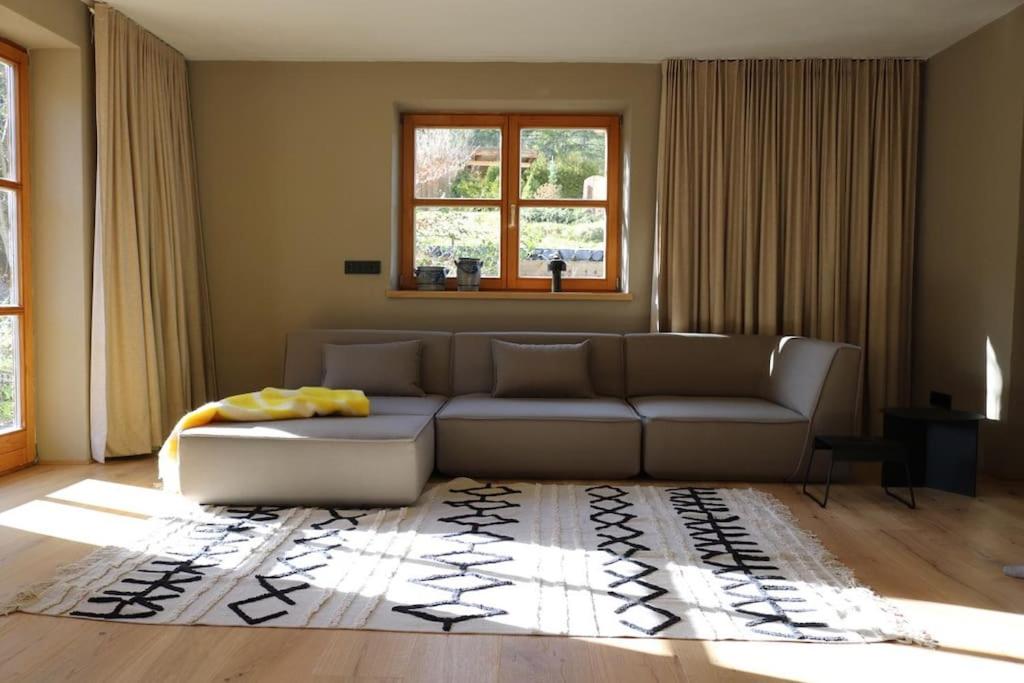 sala de estar con sofá y alfombra en Ferienhaus am Bach, Design und Sauna, en Steinberg am Rofan