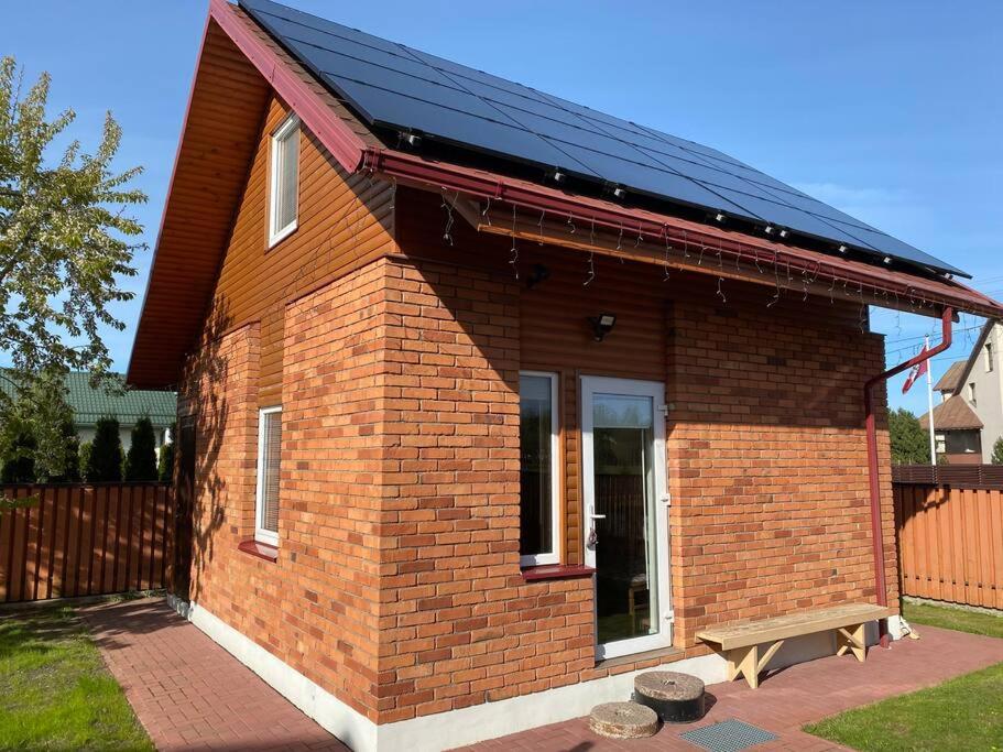 a small brick house with a solar roof at Small Red-Brick House in Kaunas