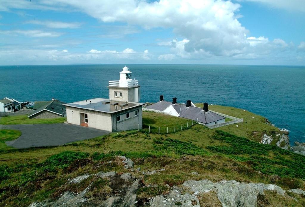 a lighthouse on top of a hill with the ocean at Sherrin in Lee