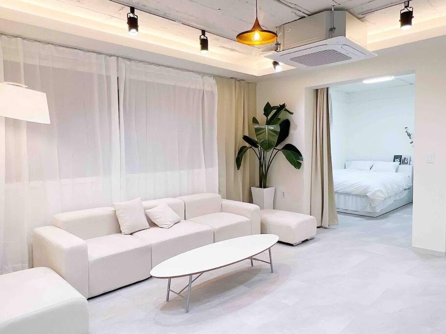 a living room with a white couch and a table at Near Hongik University Station Suite Room in Seoul