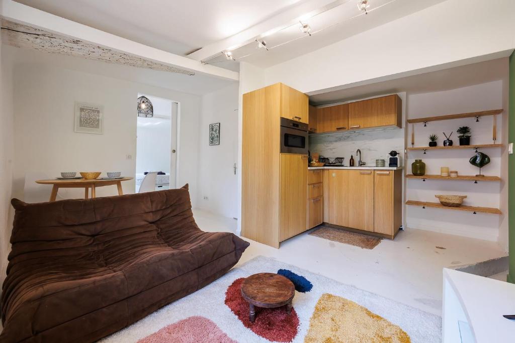 un salon avec un canapé et une cuisine dans l'établissement L'Aixquis - T2, Vieille Ville, à Aix-en-Provence