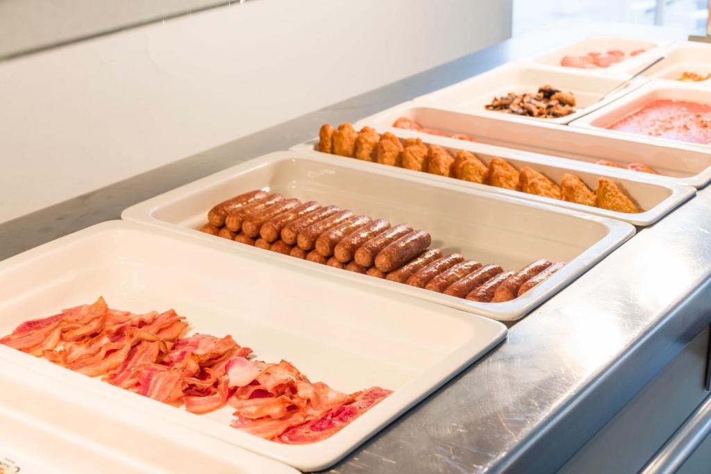 a buffet line with trays of different types of food at ILUNION Costa Sal Lanzarote in Puerto del Carmen