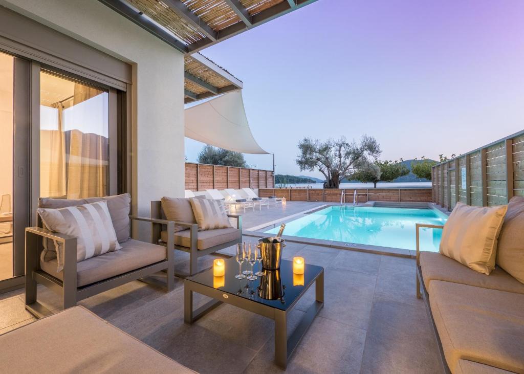 une terrasse avec une piscine et une table avec des bougies dans l'établissement Acqua Di Mare - Villa Bella, à Nydri