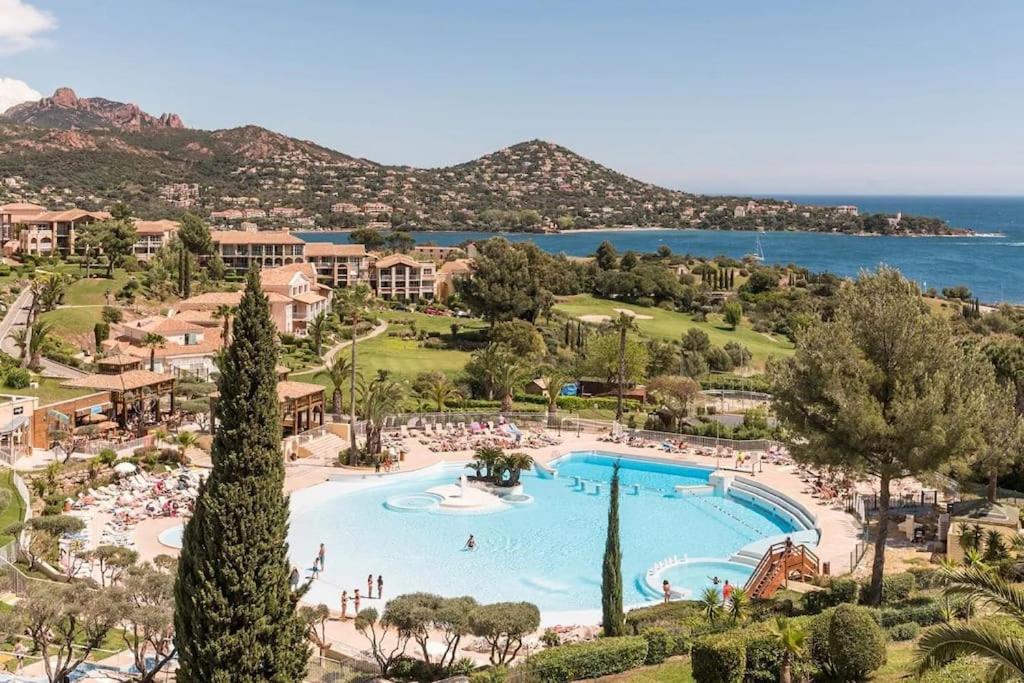 um resort com uma grande piscina junto ao oceano em Appartement Village Vacances Cap Esterel em Saint-Raphaël