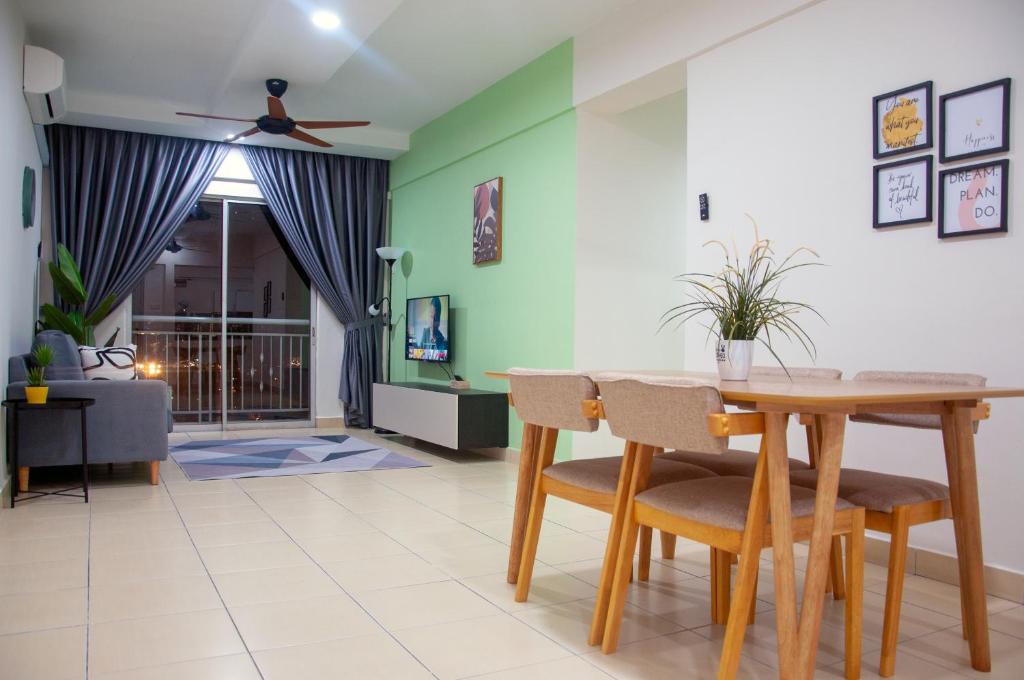 a dining room with a wooden table and chairs at Five H Family Service Apartment in Seri Kembangan