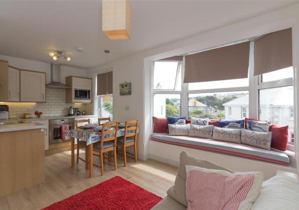 a kitchen and living room with a couch and a table at Atlantic Retreat 10a Ventnor Terrace in St Ives
