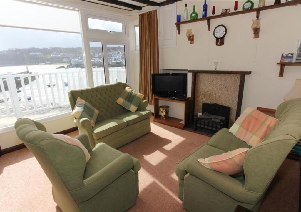 a living room with two couches and a fireplace at 4 Wharf House The Wharf in St Ives