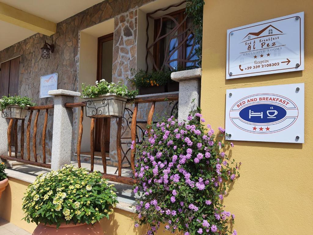 ein Gebäude mit Blumen auf einem Balkon mit Schild in der Unterkunft AL PEZ exclusive rooms in Olbia
