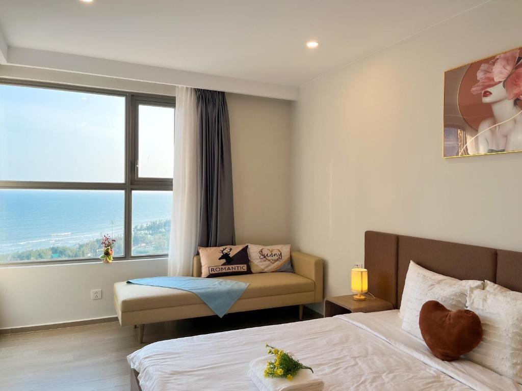 um quarto com uma cama, uma cadeira e uma janela em Sala Hotel - The Sóng Vũng Tàu em Vung Tau