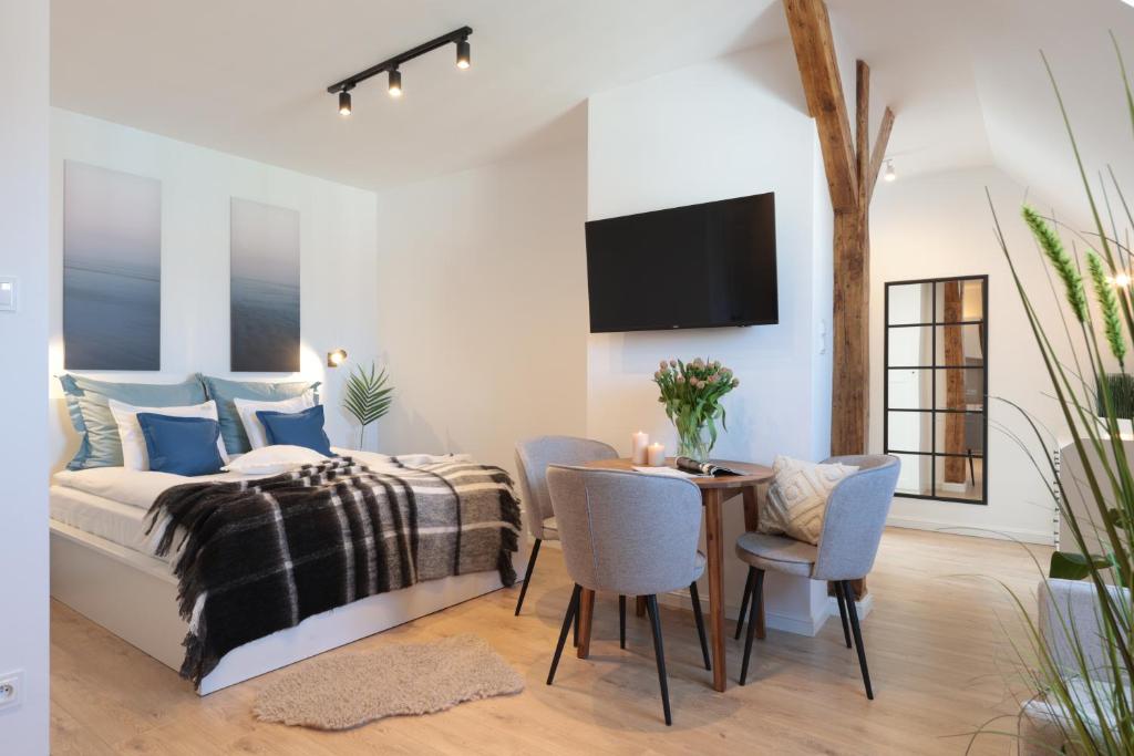 a bedroom with a bed and a table and chairs at Elite Apartments Old Town Długi Targ in Gdańsk
