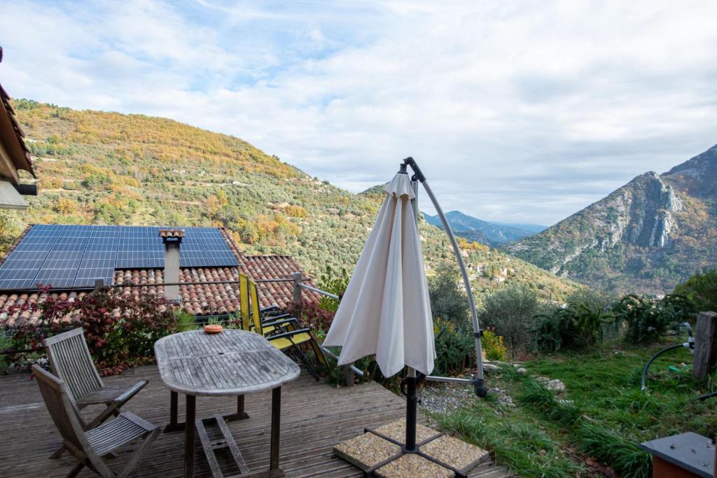 a patio with an umbrella and a table and chairs at Eco Chalet , Grande Terrasse in Sospel