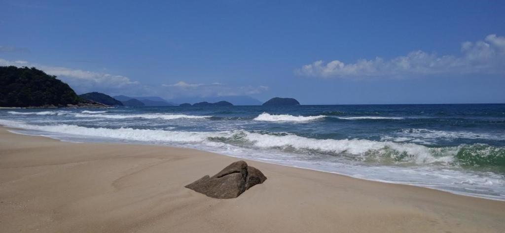 Una roccia seduta su una spiaggia vicino all'oceano di Residencial Canto da Praia - Jureia a Juréia