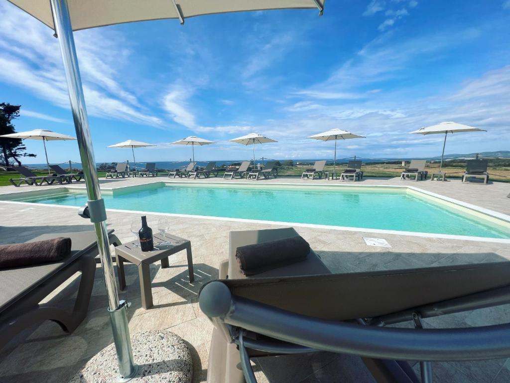 a swimming pool with a chair and an umbrella at La Casa di Spinosella in Valledoria
