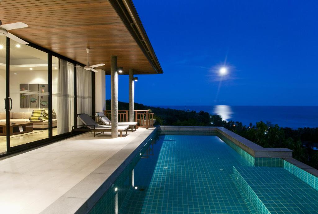 a swimming pool in a house with a view of the ocean at Villa Baan Saitara in Lamai