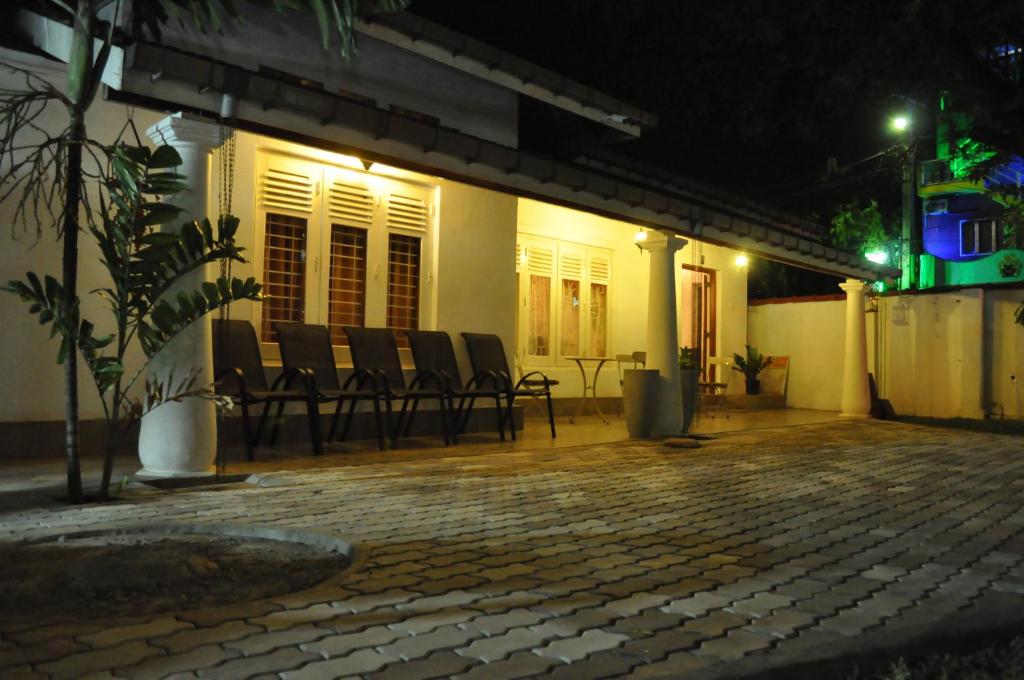 un grupo de sillas sentadas fuera de una casa por la noche en Dions Guest House, en Negombo