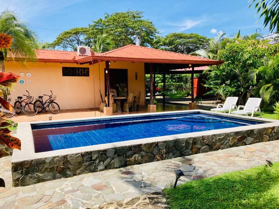 a swimming pool in front of a house at La Mona Beach House in Jacó