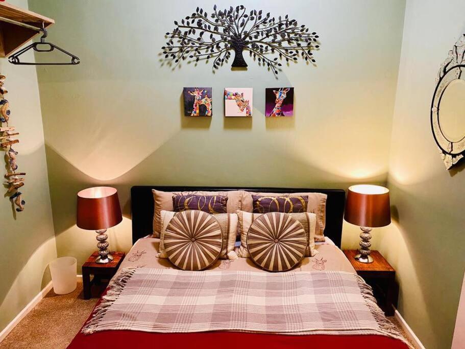 a bedroom with a bed with two lamps and a chandelier at Apartment in Old Town near the beach in Hastings