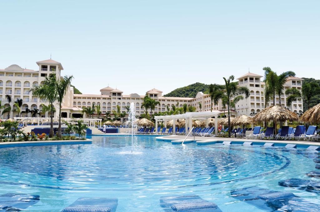 a pool at the resort with buildings in the background at Riu Guanacaste - All Inclusive in Coco