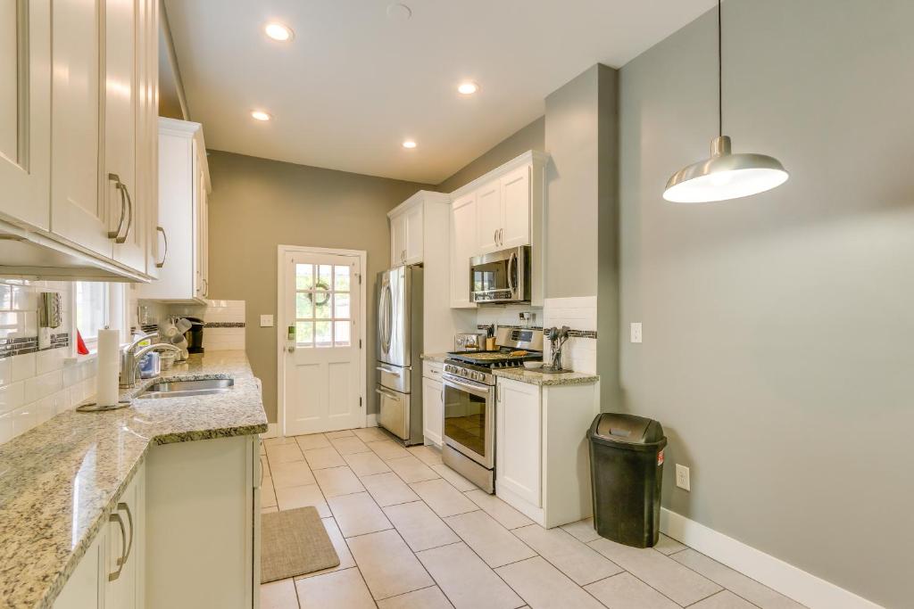 a kitchen with white cabinets and a tile floor at Cozy Maryland Abode - Gas Grill, Near Devils Den! in Emmitsburg