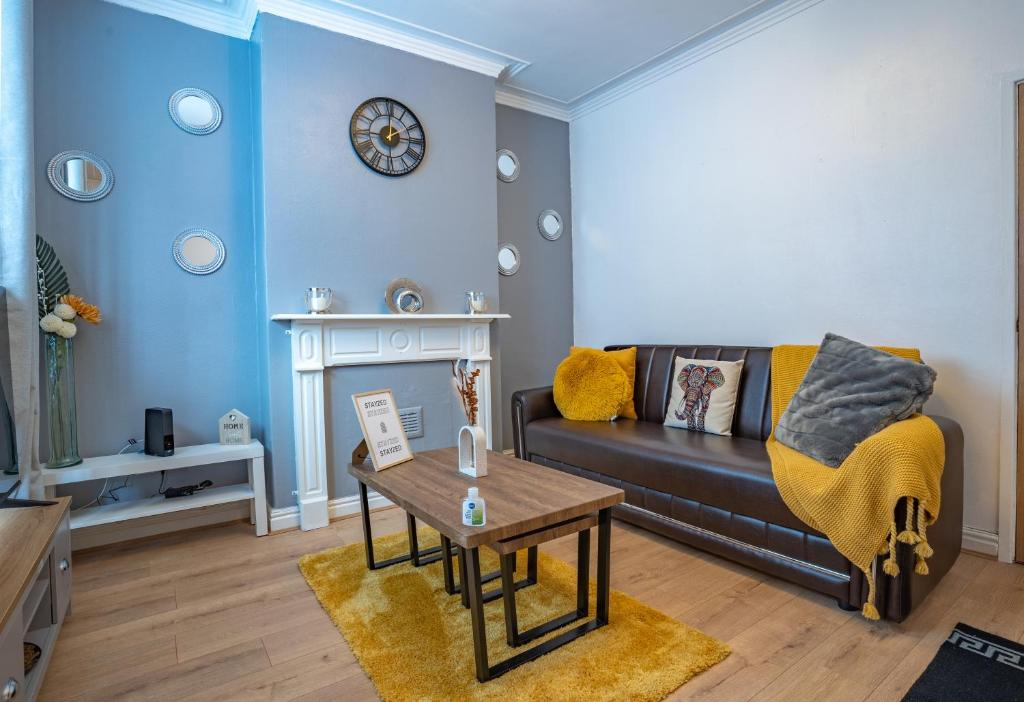 een woonkamer met een bank en een tafel bij STAYZED G - Edge Of Nottingham City Centre NG7, Great Amenities & Transport Links - Ideal for Short & Long Stays in Nottingham