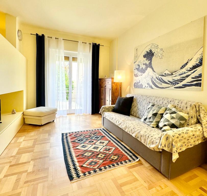 sala de estar con sofá y alfombra en Hostdomus - Casa Corallo, en Alassio