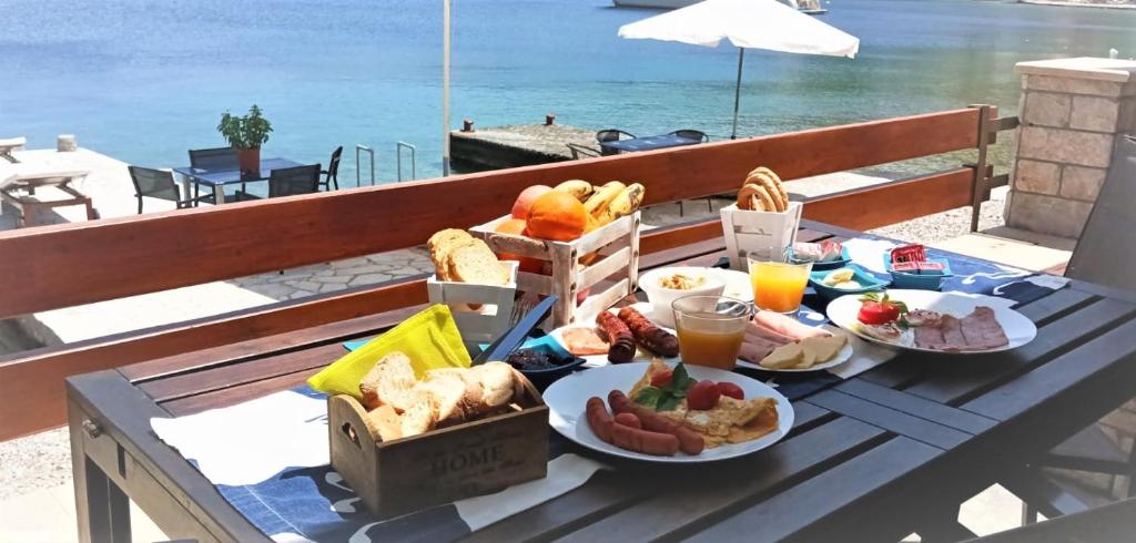 a table with plates of food on top of a balcony at Symi . VILLA CALME (Sur la Mer). in Symi