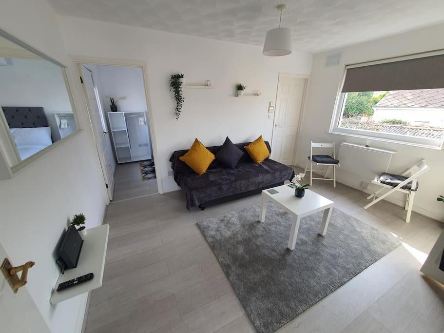 a living room with a couch and a table at Awave From It All - Escape the city life in Jaywick Sands