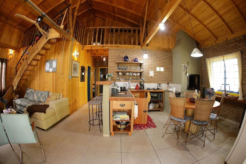 a kitchen and living room with a couch and a table at Chalé Morada Alma Gêmea in Campo Alegre
